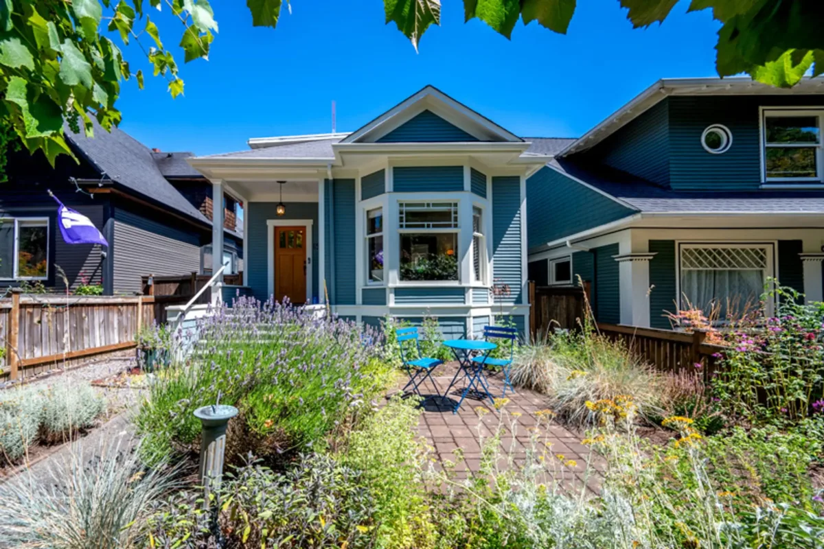 Blue Craftsman-style Queen Anne Cottage exterior and garden